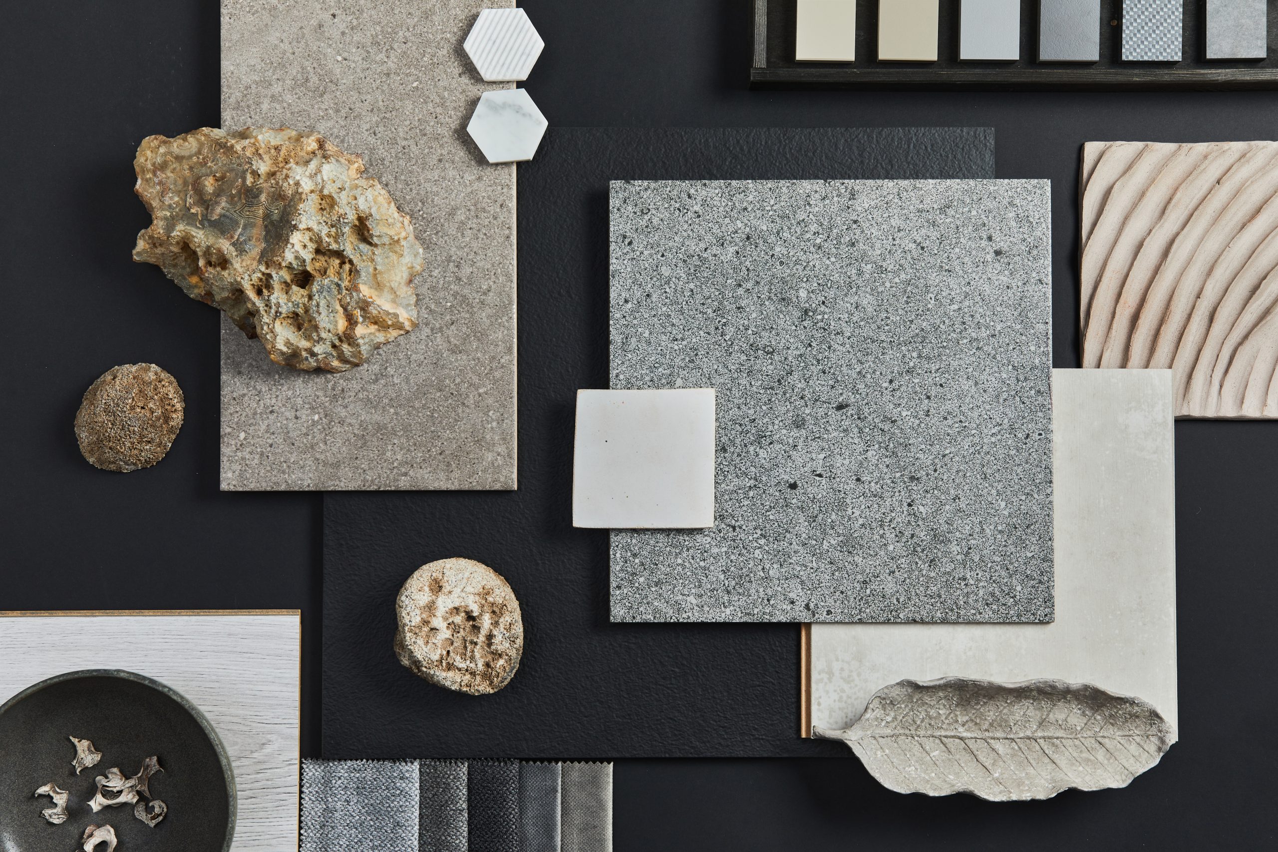 Flat lay composition of creative black architect moodboard with samples of building, textile and natural materials and personal accessories. Top view, black backgroung, template.