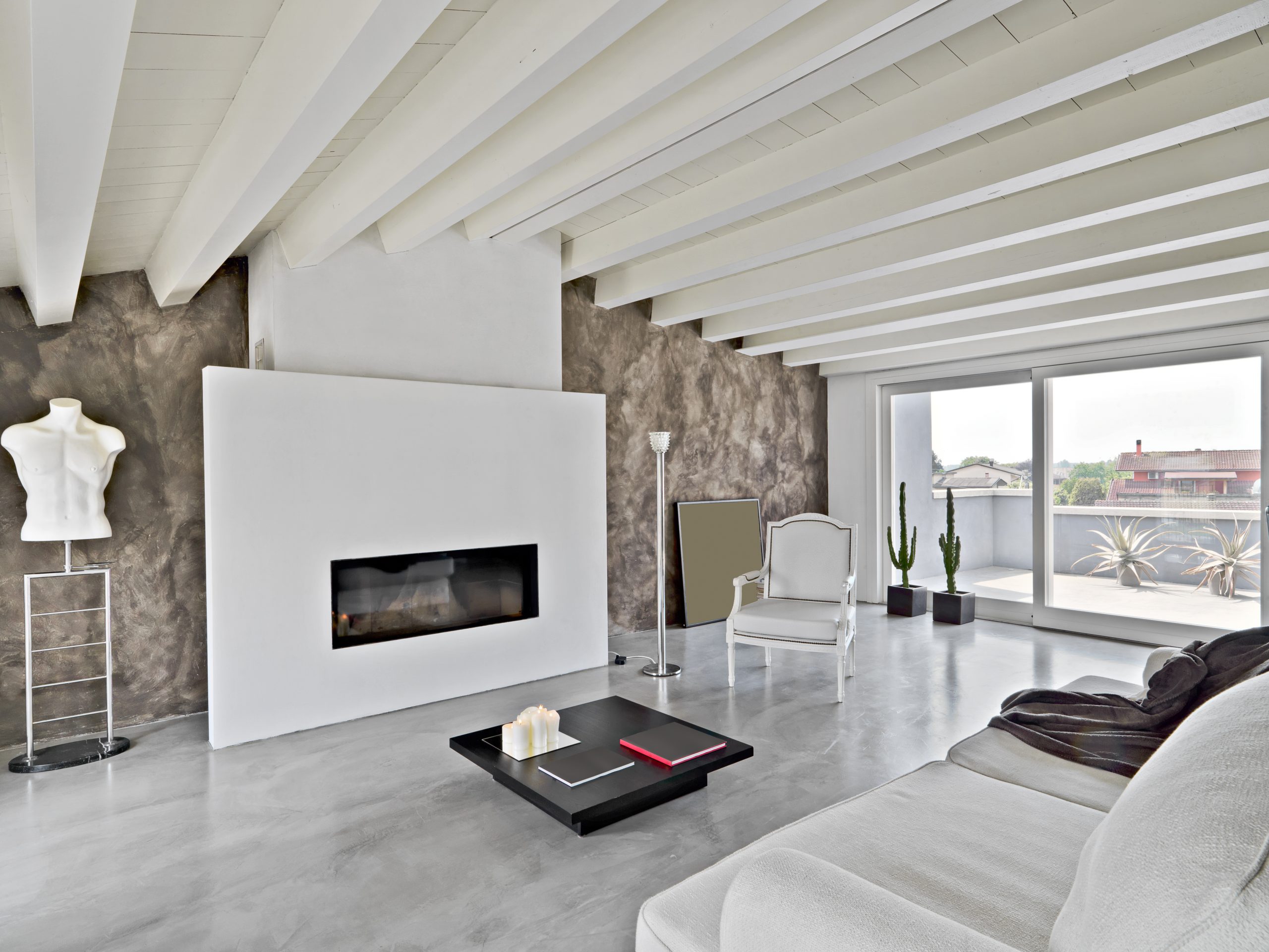 fireplace and modern leather sofa and armchair in the modern penthouse with concrete floor