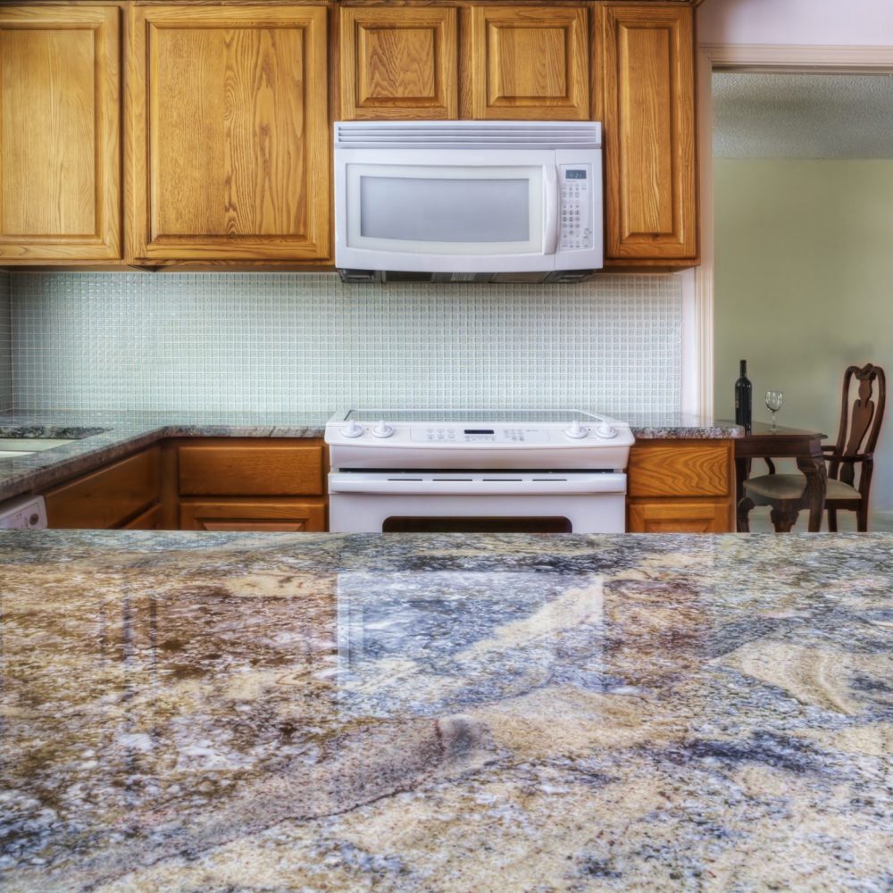 Granite counter reflecting kitchen cabinets